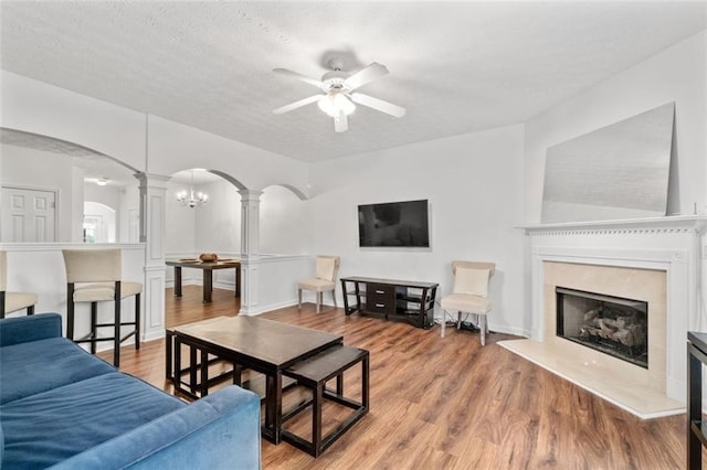 2826 Snapfinger Mnr, Decatur, GA 30035 - living room featuring wood finished floors, ceiling fan, ornate columns, arched walkways, and a premium fireplace