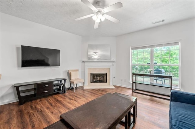 2826 Snapfinger Mnr, Decatur, GA 30035 - living room featuring a fireplace with raised hearth, a ceiling fan, wood finished floors, and visible vents