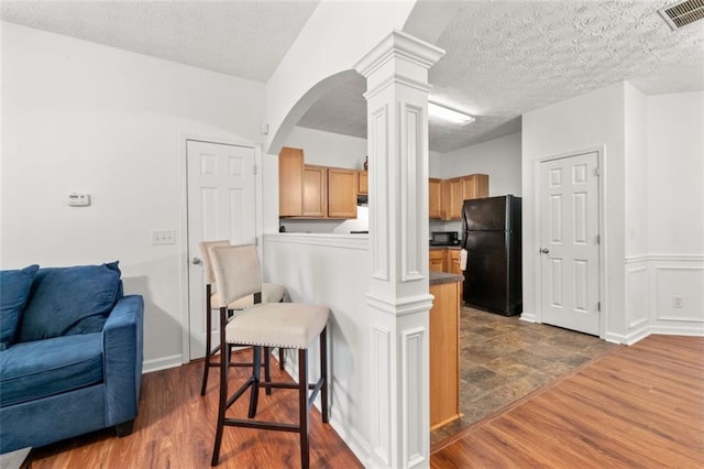 2826 Snapfinger Mnr, Decatur, GA 30035 - kitchen with visible vents, freestanding refrigerator, decorative columns, a peninsula, and a kitchen bar
