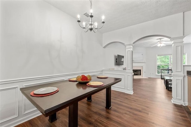 2826 Snapfinger Mnr, Decatur, GA 30035 - dining area with arched walkways, a fireplace with raised hearth, ornate columns, and dark wood-style floors