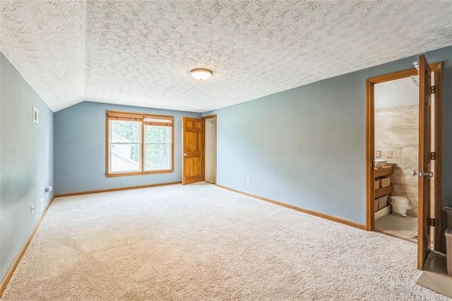 unfurnished bedroom featuring baseboards, a textured ceiling, and carpet