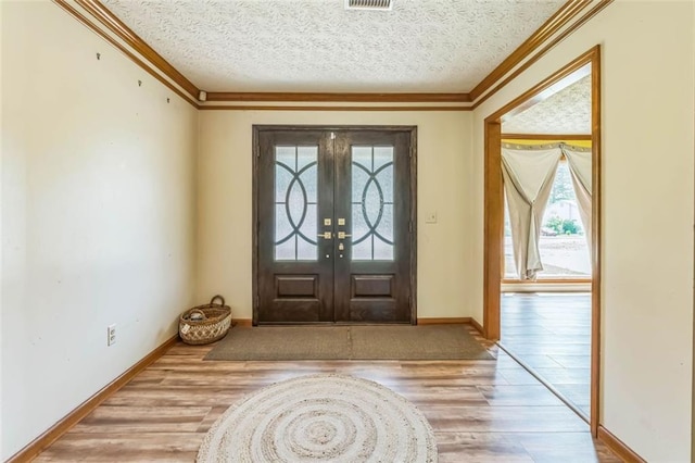 entryway featuring crown molding, baseboards, and wood finished floors