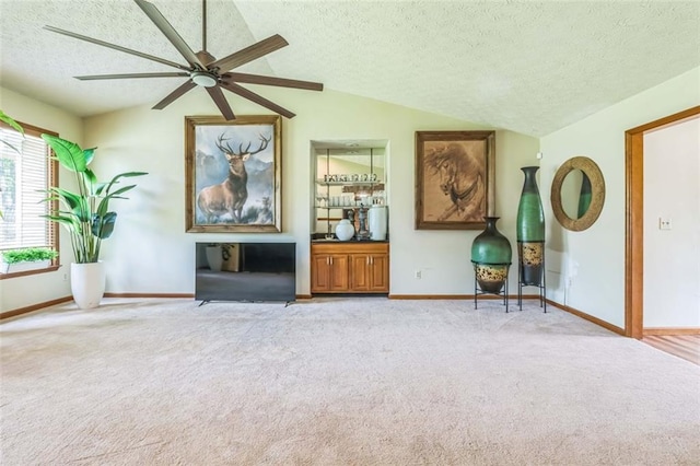 sitting room with carpet floors, a ceiling fan, a textured ceiling, and lofted ceiling