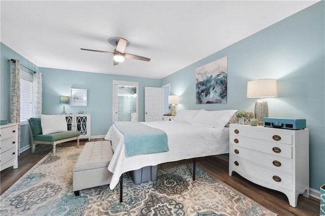 bedroom featuring baseboards, wood finished floors, ensuite bath, and a ceiling fan
