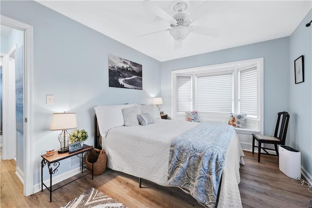 bedroom featuring baseboards, ceiling fan, and wood finished floors