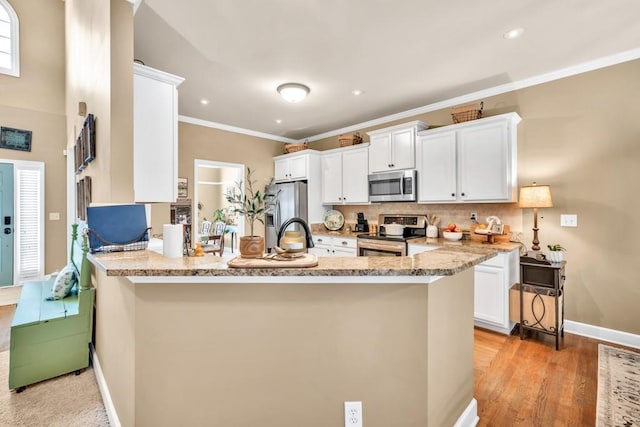 3125 Flatbottom Dr, Dacula, GA 30019 - kitchen featuring a peninsula, baseboards, white cabinetry, tasteful backsplash, and stainless steel appliances