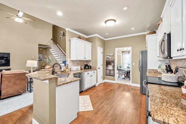 3125 Flatbottom Dr, Dacula, GA 30019 - kitchen with a sink, open floor plan, white cabinetry, a ceiling fan, and appliances with stainless steel finishes