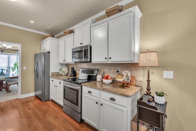 3125 Flatbottom Dr, Dacula, GA 30019 - kitchen featuring decorative backsplash, ornamental molding, white cabinetry, light wood-style flooring, and stainless steel appliances