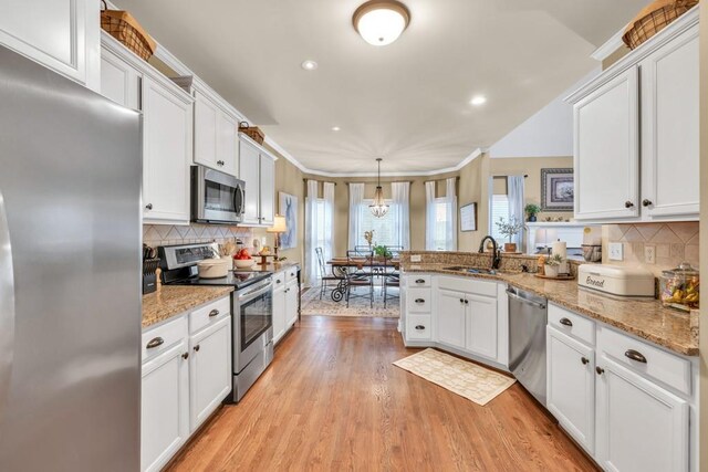 3125 Flatbottom Dr, Dacula, GA 30019 - kitchen featuring appliances with stainless steel finishes, a sink, a peninsula, white cabinetry, and decorative backsplash