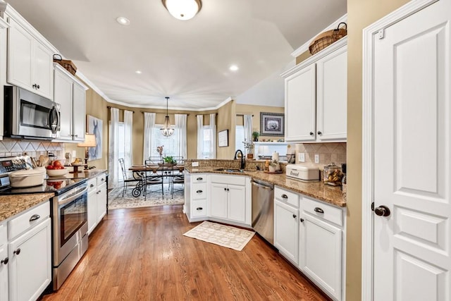 3125 Flatbottom Dr, Dacula, GA 30019 - kitchen with a peninsula, appliances with stainless steel finishes, white cabinetry, and a sink