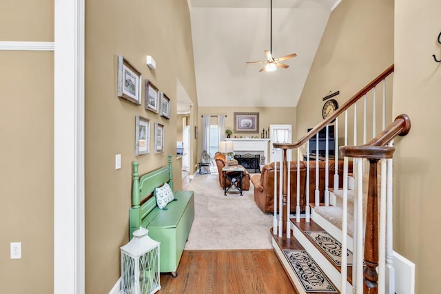 3125 Flatbottom Dr, Dacula, GA 30019 - foyer featuring a fireplace, high vaulted ceiling, stairs, a ceiling fan, and wood finished floors