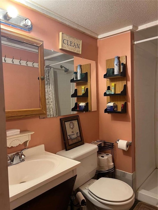 bathroom featuring a textured ceiling, a shower stall, toilet, and a sink