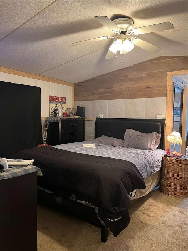 bedroom with a textured ceiling, lofted ceiling, wooden walls, and carpet