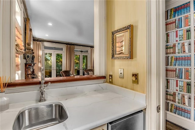 kitchen featuring light stone counters, a sink, and recessed lighting