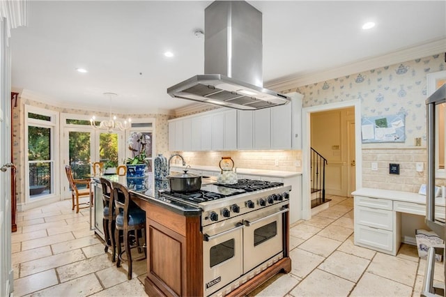 kitchen featuring wallpapered walls, island range hood, range with two ovens, and ornamental molding