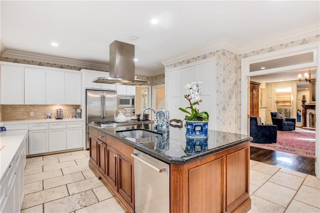 kitchen featuring built in appliances, a sink, ornamental molding, dark stone countertops, and island exhaust hood