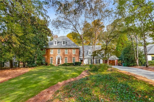 colonial house with driveway and a front lawn