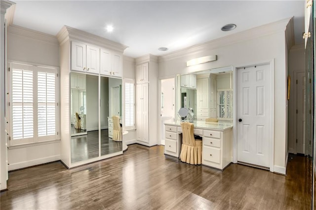 bathroom featuring vanity, baseboards, crown molding, and wood finished floors