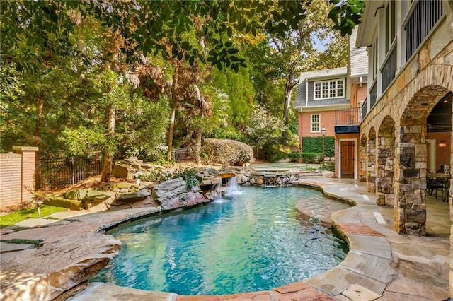 view of pool with a pool with connected hot tub, a patio, and fence