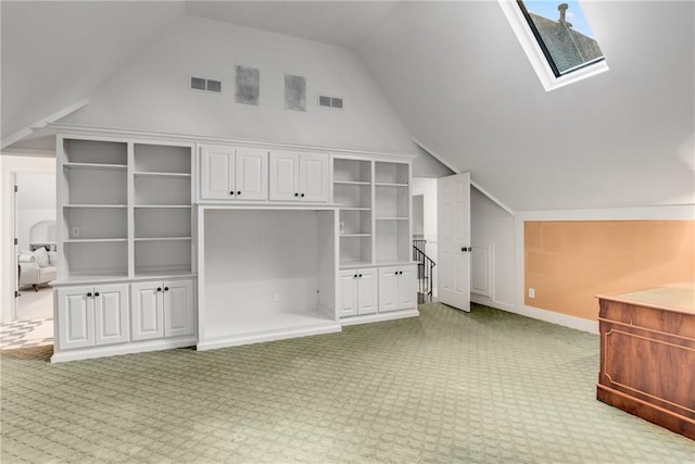 additional living space featuring vaulted ceiling with skylight, visible vents, and light colored carpet