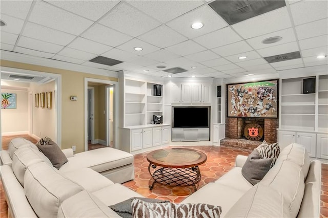 living room featuring built in shelves, recessed lighting, visible vents, and a fireplace