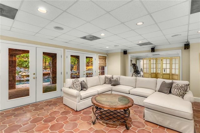 living area with french doors, a drop ceiling, recessed lighting, and a healthy amount of sunlight