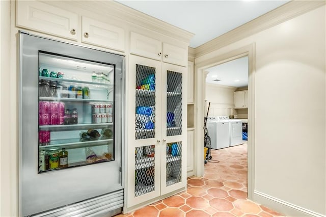 doorway featuring french doors, light tile patterned flooring, crown molding, and washer and clothes dryer