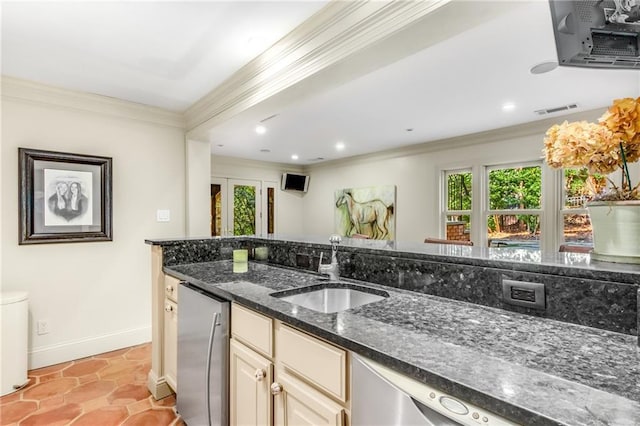 kitchen with visible vents, baseboards, dark stone countertops, crown molding, and a sink