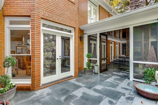 exterior space with brick siding, a patio area, and french doors