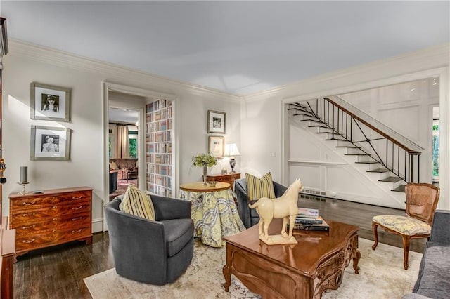 living area featuring stairs, ornamental molding, and wood finished floors