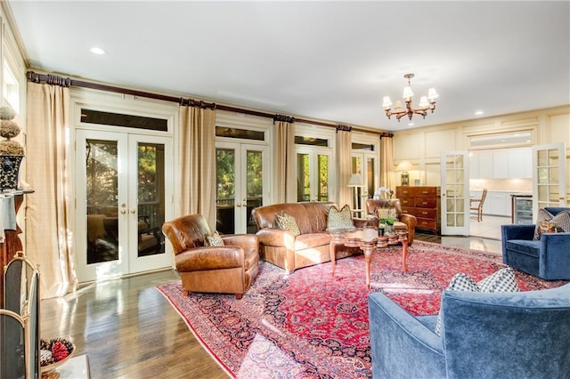 living area with french doors, an inviting chandelier, and wood finished floors