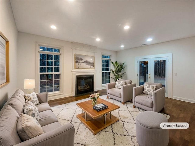 living room featuring french doors, wood finished floors, a glass covered fireplace, and recessed lighting