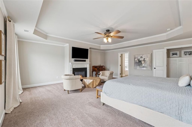 406 Dunaway Ct, Grayson, GA 30017 - carpeted bedroom with crown molding, a glass covered fireplace, a tray ceiling, and a ceiling fan