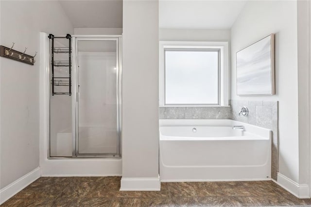 bathroom with baseboards, a stall shower, and a garden tub