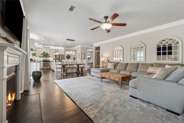 406 Dunaway Ct, Grayson, GA 30017 - living room with a warm lit fireplace, ceiling fan, crown molding, dark wood-style floors, and recessed lighting