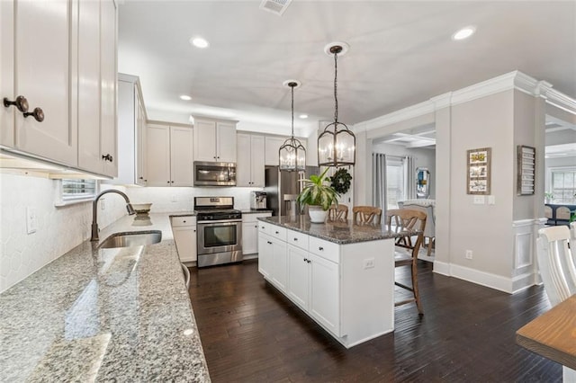 406 Dunaway Ct, Grayson, GA 30017 - kitchen featuring appliances with stainless steel finishes, a breakfast bar, light stone countertops, a center island, and hanging light fixtures