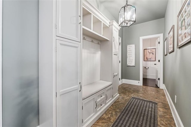 mudroom with baseboards and a chandelier