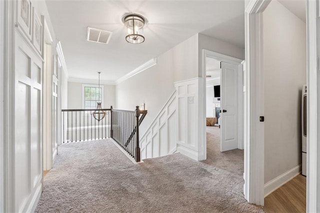 406 Dunaway Ct, Grayson, GA 30017 - hallway with an upstairs landing, a chandelier, carpet, and crown molding
