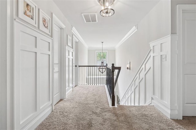 406 Dunaway Ct, Grayson, GA 30017 - hallway featuring an upstairs landing, carpet floors, a decorative wall, crown molding, and a chandelier