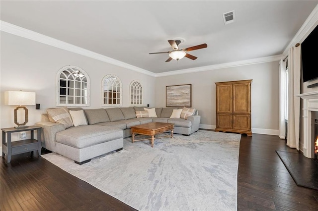 living room with visible vents, dark wood-type flooring, ceiling fan, and ornamental molding