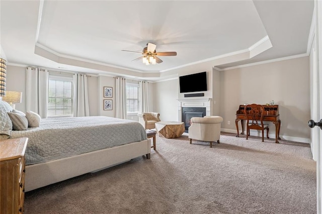 bedroom featuring a fireplace, baseboards, ornamental molding, a tray ceiling, and carpet flooring