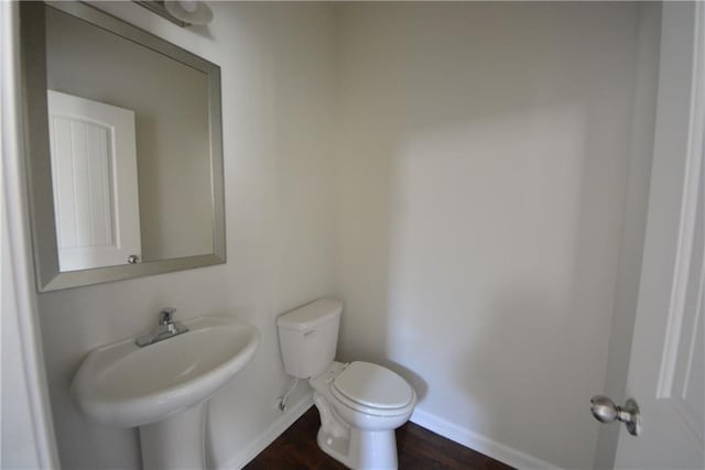 bathroom with toilet, baseboards, and a sink