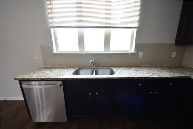 kitchen featuring stainless steel dishwasher, decorative backsplash, plenty of natural light, and a sink