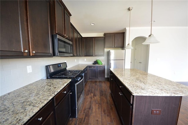 kitchen featuring dark brown cabinets, a kitchen island, dark wood-style flooring, and stainless steel appliances