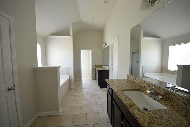 full bathroom featuring a healthy amount of sunlight, a garden tub, and a sink