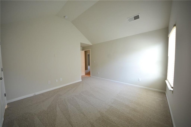 carpeted spare room with visible vents, baseboards, and vaulted ceiling