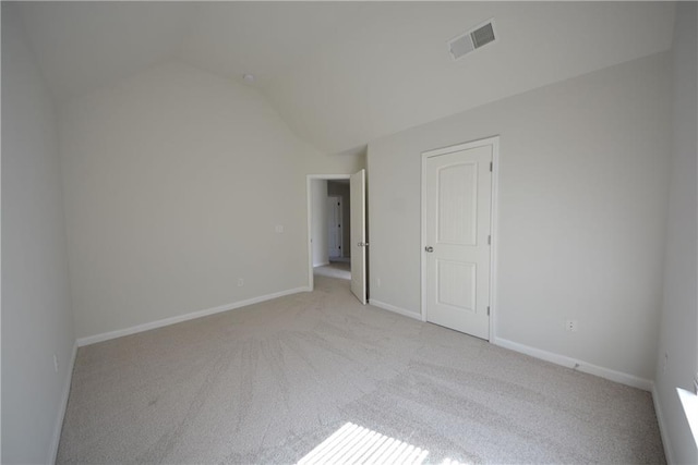 unfurnished bedroom featuring baseboards, visible vents, lofted ceiling, and light carpet