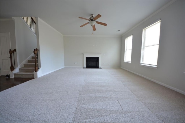 unfurnished living room with stairway, baseboards, ornamental molding, and a fireplace with flush hearth