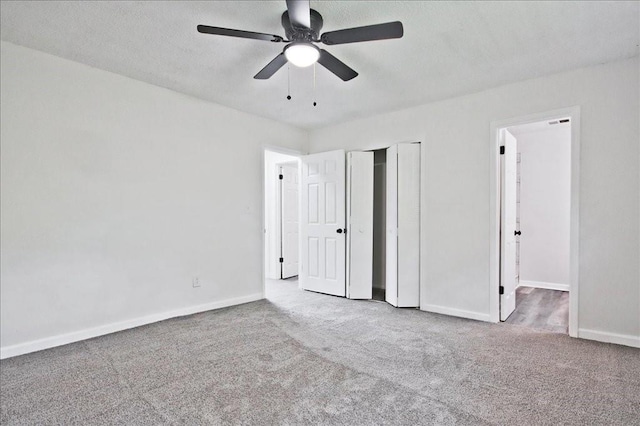 unfurnished bedroom with ceiling fan, visible vents, baseboards, a closet, and carpet flooring