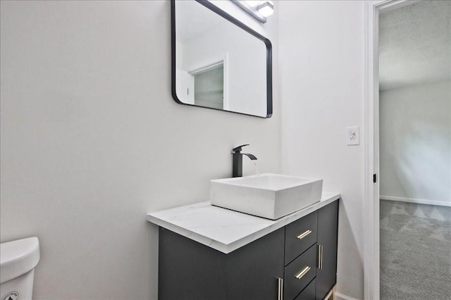 bathroom with vanity, baseboards, and toilet